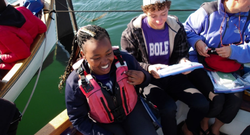 People smile while sitting in a boat